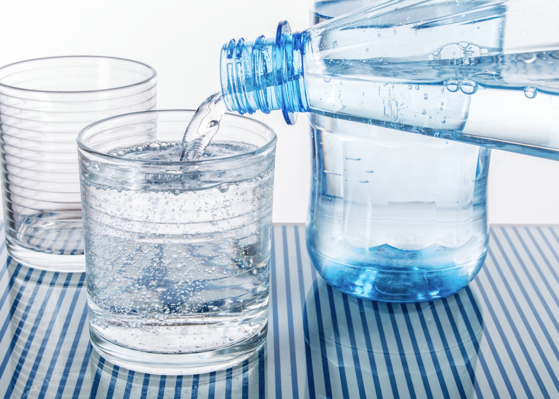 Zwei Gläser werden mit unterschiedlichem Wasser gefüllt, um die verschiedenen Anforderungen an Wasseraufbereitung zu illustrieren