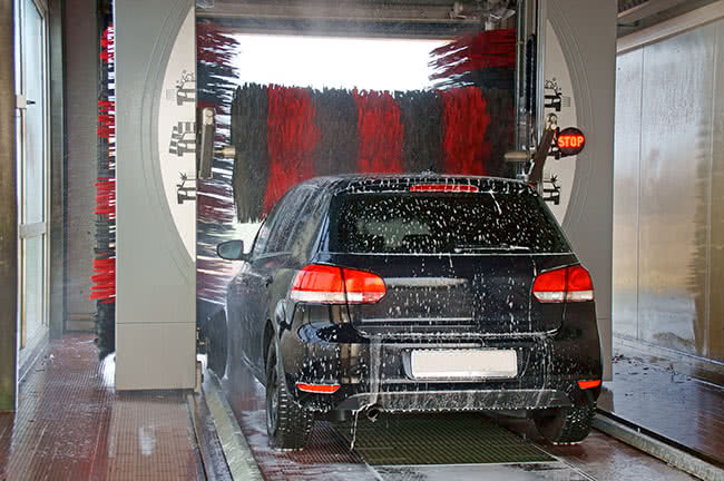 Ein Auto in einer Waschanlage, die durch professionelle Umkehrosmoseanlagen fleckenfreies Wasser nutzen können.